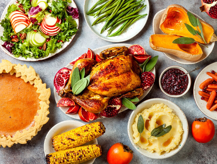 Thanksgiving dinner spread with roasted turkey, mashed potatoes, green beans, and pumpkin pie.