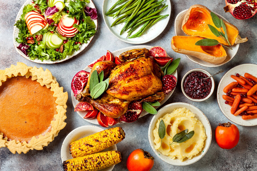 Thanksgiving dinner spread with roasted turkey, mashed potatoes, green beans, and pumpkin pie.